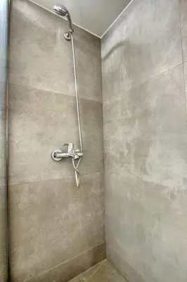 a shower with a shower head in a bathroom at Sweet and modern flat at Palaio faliro in Athens