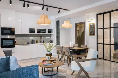 a living room with a table and a kitchen at Jun in Athens