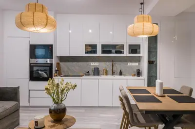 a kitchen and dining room with white cabinets and a table at Jun in Athens