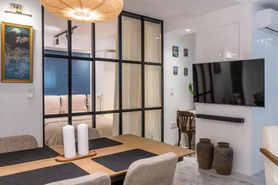 a dining room with a table and a tv at Jun in Athens