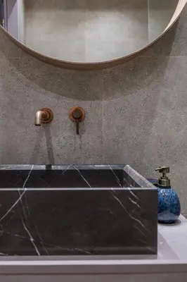 a bathroom sink with a mirror and a blue vase at Jun in Athens