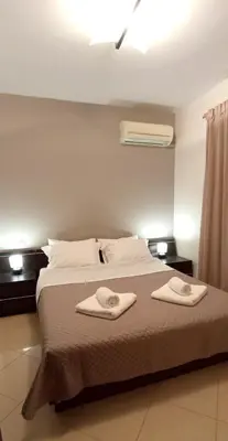 a bedroom with a bed with two towels on it at The Beach House in Porto Rafti