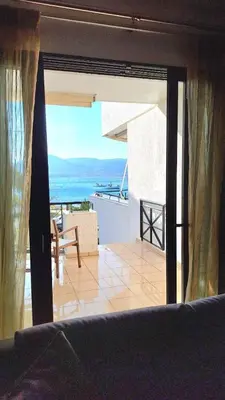 a room with a balcony with a view of the ocean at The Beach House in Porto Rafti