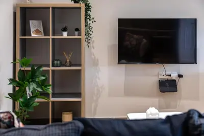 a living room with a tv on a wall at Mikrolimano Gem: Serene 1BR Apartment in Piraeus