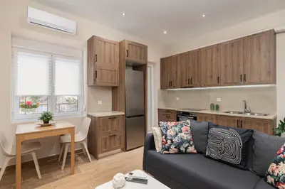 a living room with a couch and a kitchen at Mikrolimano Gem: Serene 1BR Apartment in Piraeus