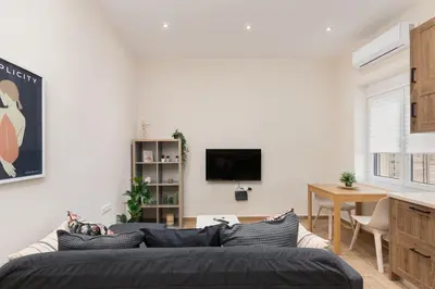 a living room with a couch and a tv at Mikrolimano Gem: Serene 1BR Apartment in Piraeus