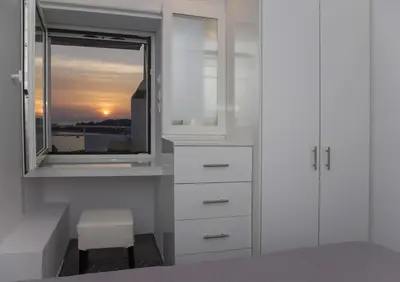 a white bedroom with a window and a chair at Luxury penthouse with stunning riviera view by GHH in Athens