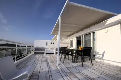 a balcony with a table and chairs on a building at Luxury penthouse with stunning riviera view by GHH in Athens