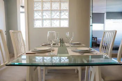 a glass table with chairs and wine glasses on it at 3C’s Athens South @Delta: SNFCC / Faliro Seaview Penthouse in Athens