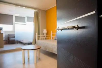a door to a bedroom with a bed and a stool at 3C’s Athens South @Delta: SNFCC / Faliro Seaview Penthouse in Athens