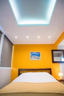 a bedroom with a bed with yellow walls and a skylight at 3C’s Athens South @Delta: SNFCC / Faliro Seaview Penthouse in Athens