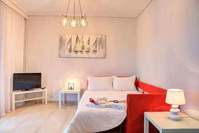 a small room with a bed and a tv at Beautiful apartment in Glyfada center in Athens