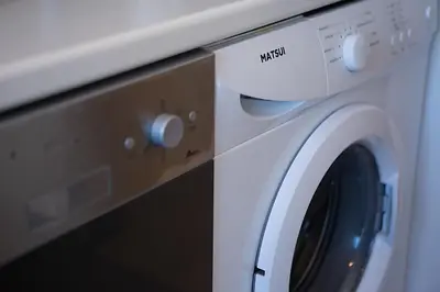 a white washing machine sitting next to a microwave at Beautiful apartment in Glyfada center in Athens