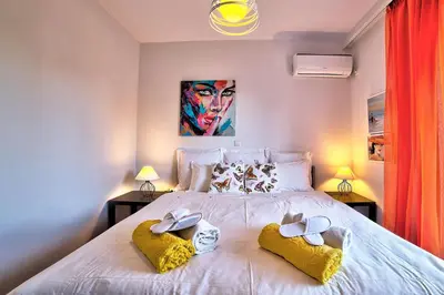 a bedroom with a large white bed with two towels at Beautiful apartment in Glyfada center in Athens