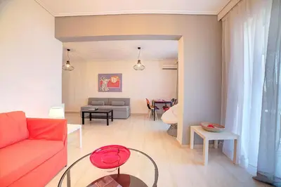 a living room with a red couch and a table at Beautiful apartment in Glyfada center in Athens