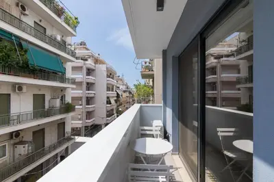 a balcony with tables and chairs on a building at Athens Trikoupi Suite D1 in Athens