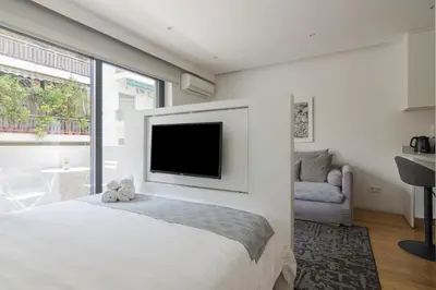 a bedroom with a large bed with a tv on the wall at Athens Trikoupi Suite D1 in Athens