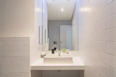 a white bathroom with a sink and a mirror at Athens Trikoupi Suite D1 in Athens