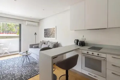 a kitchen with a counter and a living room with a couch at Athens Trikoupi Suite D1 in Athens