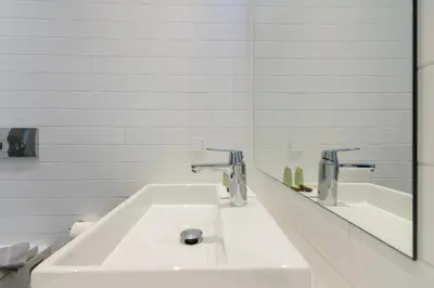 a white bathroom with a sink and a mirror at Athens Trikoupi Suite D1 in Athens