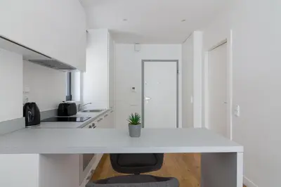 a white kitchen with a white counter and a chair at Athens Trikoupi Suite D1 in Athens