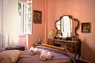 a bedroom with a bed with a dresser and a mirror at Athens Quinta in Athens