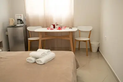 a room with a table with towels on a bed at Anesis Airport rooms 102 in Koropíon