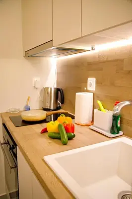 a kitchen counter with vegetables on a cutting board at Suites Rania in Áyios Yeóryios