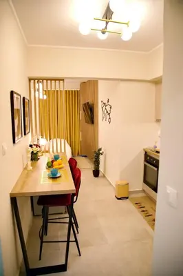 a kitchen and dining room with a table and a living room at Suites Rania in Áyios Yeóryios