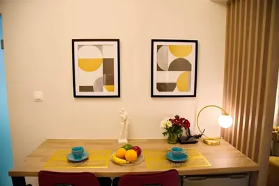 a table with fruit on it with two pictures on the wall at Suites Rania in Áyios Yeóryios