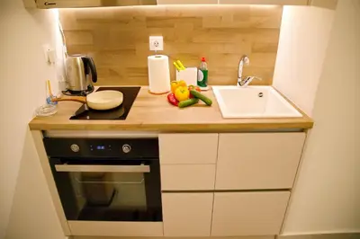 a small kitchen with a sink and a stove at Suites Rania in Áyios Yeóryios