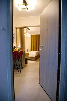 a door to a room with a bedroom and a table at Suites Rania in Áyios Yeóryios
