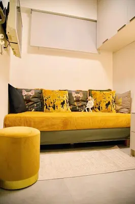 a yellow couch in a living room with a dog on it at Suites Rania in Áyios Yeóryios