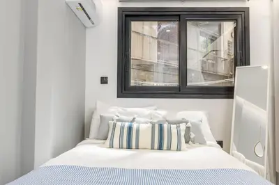 a bedroom with a white bed with a window at The Oh Boy Studio in Athens in Athens
