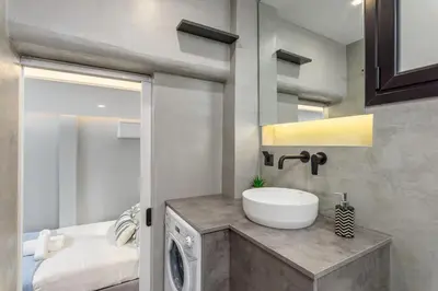 a bathroom with a sink and a washing machine at The Oh Boy Studio in Athens in Athens