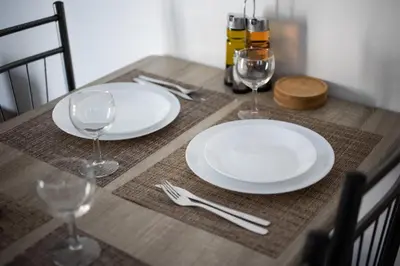a table with white plates and wine glasses on it at Theia 1-Bedroom Apartment in Athens in Athens