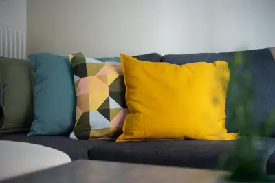 a blue couch with colorful pillows on it at Theia 1-Bedroom Apartment in Athens in Athens