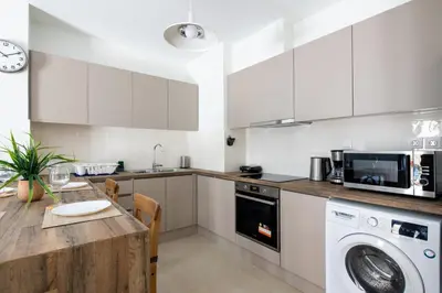 a kitchen with white cabinets and a table and a microwave at Astrea 1- Bedroom Apartment in Athens in Athens