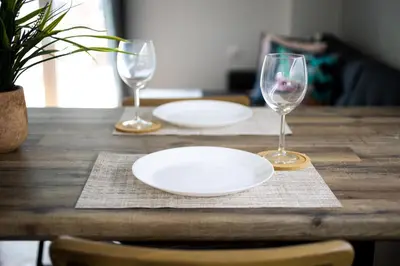 a wooden table with two empty plates and two wine glasses at Astrea 1- Bedroom Apartment in Athens in Athens