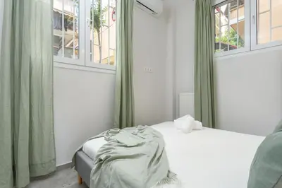 a small bedroom with a bed and two windows at Penelope Charming 2Bedroom Apartment in Athens in Athens