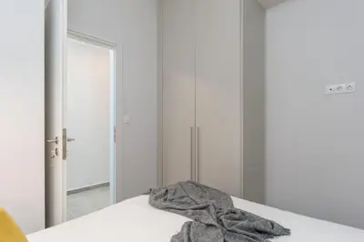 a robe sitting on a bed in front of a mirror at Penelope Charming 2Bedroom Apartment in Athens in Athens