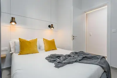 a bedroom with a white bed with yellow pillows at Penelope Charming 2Bedroom Apartment in Athens in Athens