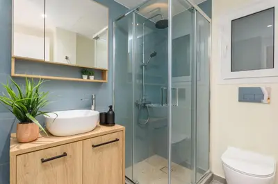 a bathroom with a glass shower with a sink and a toilet at Penelope Charming 2Bedroom Apartment in Athens in Athens