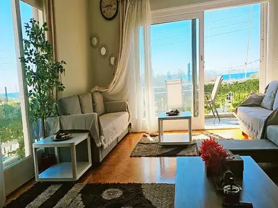 a living room with a couch and a large window at Luxurious Palace Marina Alimos in Athens