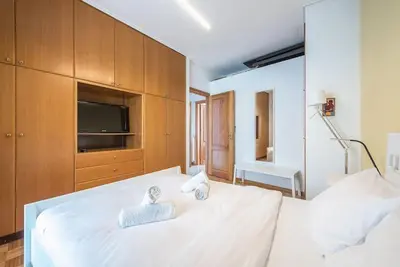 a bedroom with a large white bed with a television at Calipso in Piraeus