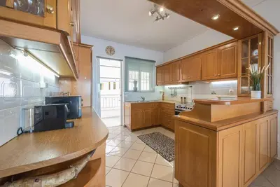 a large kitchen with wooden cabinets and a counter top at Calipso in Piraeus