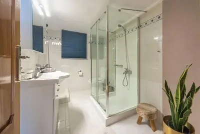 a bathroom with a glass shower and a sink at Calipso in Piraeus