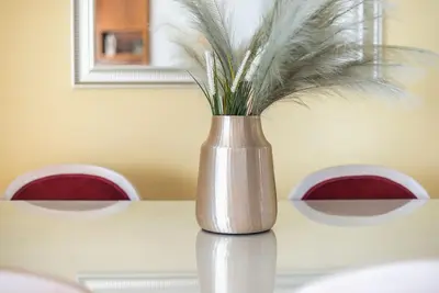 a silver vase with feathers in it sitting on a table at Calipso in Piraeus
