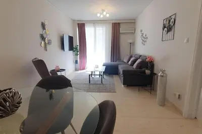 a living room with a glass table and a couch at Seaside Beauty 5 min Vouliagmeni Beach in Athens