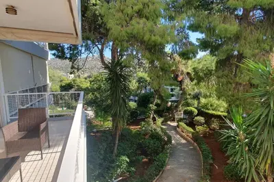 a balcony of a house with trees and plants at Seaside Beauty 5 min Vouliagmeni Beach in Athens